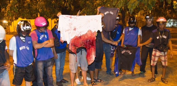 Amigos mostram camisa ensanguentada do um mototaxista Fábio da Silva de Barros, 28 - Fernando Quevedo / Agência O Globo