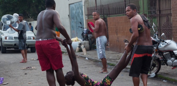 Mulher é carregada durante a reintegração de posse da "Favela da Telerj", terreno que pertence a Oi, no Engenho Novo, na zona norte do Rio de Janeiro - ERBS Jr./ Frame/ Estadão Conteúdo