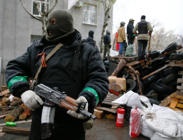 13.abr.2014 - Homem armado defende barricada em frente à sede da polícia em Slaviansk, na Ucrânia