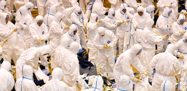Trabalhadores se preparam, neste domingo (13), para sacrificar frangos no Japão - Kyodo/Reuters
