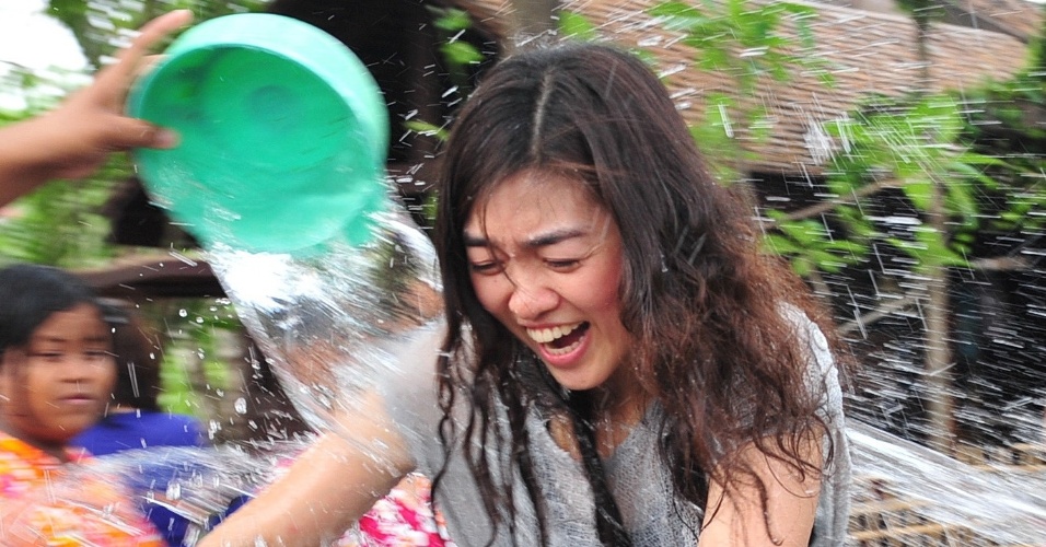 13.abr.2014 - Pessoas jogam água em mulher durante o festival Songkran, próximo a Bancoc, na Tailândia. A festividade, também conhecida como festival da Água, é celebrada tradicionalmente no país para marcar a chegada do Ano-Novo, normalmente entre os dias 13 de 15 de abril