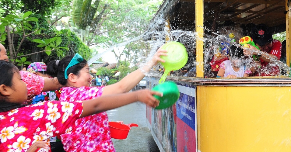 13.abr.2014 - Pessoas lançam água dentro de bonde durante o festival Songkran, próximo a Bancoc, na Tailândia. A festividade, também conhecida como festival da Água, é celebrada tradicionalmente no país para marcar a chegada do Ano-Novo, normalmente entre os dias 13 de 15 de abril