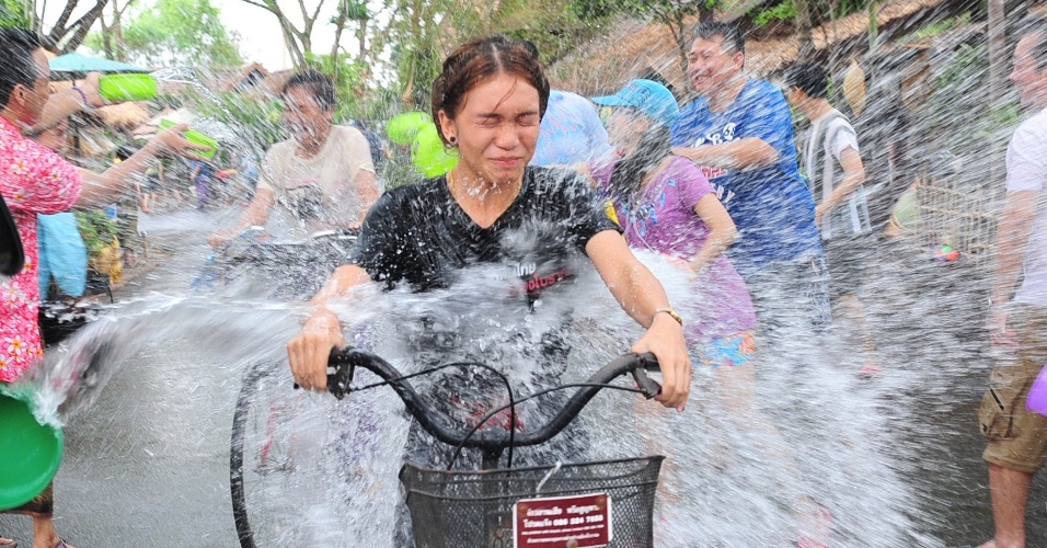 13.abr.2014 - Pessoas lançam água em uma ciclista durante o festival Songkran, próximo a Bancoc, na Tailândia. A festividade, também conhecida como festival da Água, é celebrada tradicionalmente no país para marcar a chegada do Ano-Novo, normalmente entre os dias 13 de 15 de abril