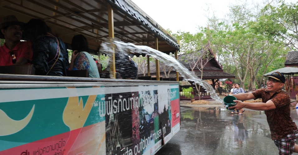 13.abr.2014 - Um homem lança água dentro de bonde durante o festival Songkran, próximo a Bancoc, na Tailândia. A festividade, também conhecida como festival da Água, é celebrada tradicionalmente no país para marcar a chegada do Ano-Novo, normalmente entre os dias 13 de 15 de abril