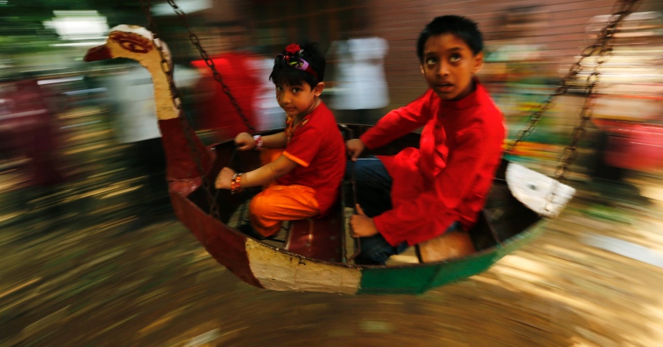 14.abr.2014 - Crianças brincam em um carrossel durante a celebração do Pohela Boishakh, o primeiro dia do ano novo Bengali, em Daca (Bangladesh)