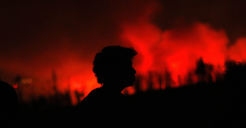 14.abr.2014 - Uma pessoa observa as chamas na madrugada, durante um incêndio florestal em Valparaíso, no Chile