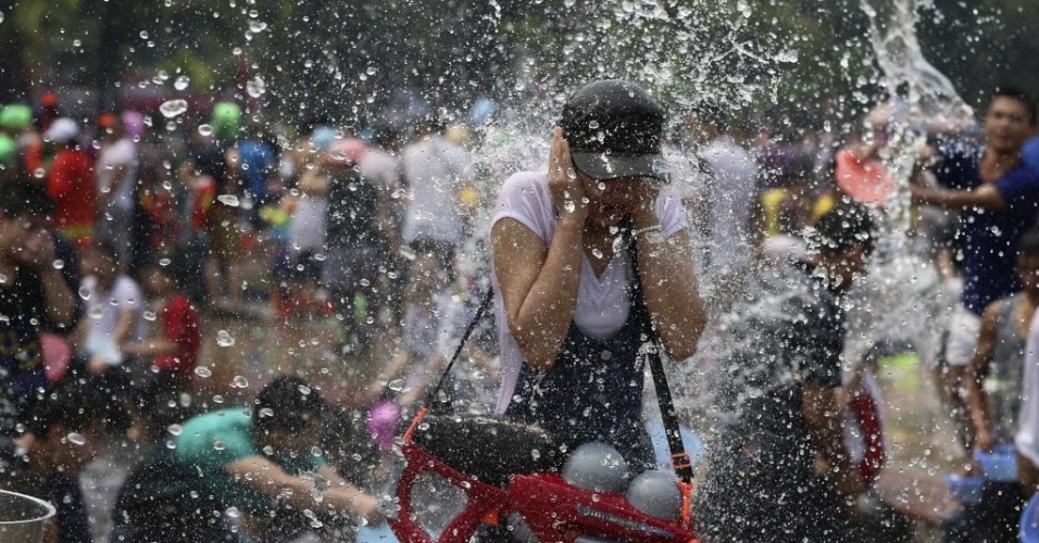15.abr.2014 - Mulher tenta se esquivar durante o Festival da Água no sudoeste da China. A festividade marca o Ano-Novo da minoria Dai que celebra a chegada do ano 1376  