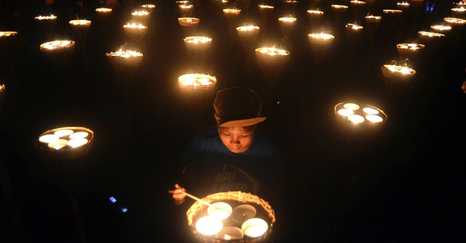15.abr.2014 - Voluntário acende velas durante o evento "Luz de Paz nas Filipinas" na cidade filipina de Oton