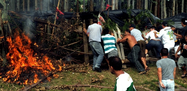 Moradores tocam fogo em barricada montada por invasores de terreno público em Florianópolis - Guto Kuerten/Agência RBS/Agência O Globo