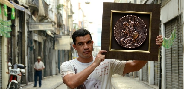 Devoto de São Jorge, o PM Marcelo Santos de Freitas carrega imagem no dia do santo - Lucas Landau/UOL