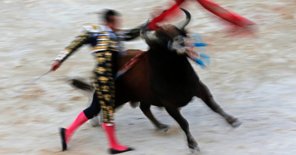 24.abr.2014 - Fotografia com baixa velocidade mostraum toureiro espanhol na arena, durante a tradicional feira de Páscoa, em Arles, na França