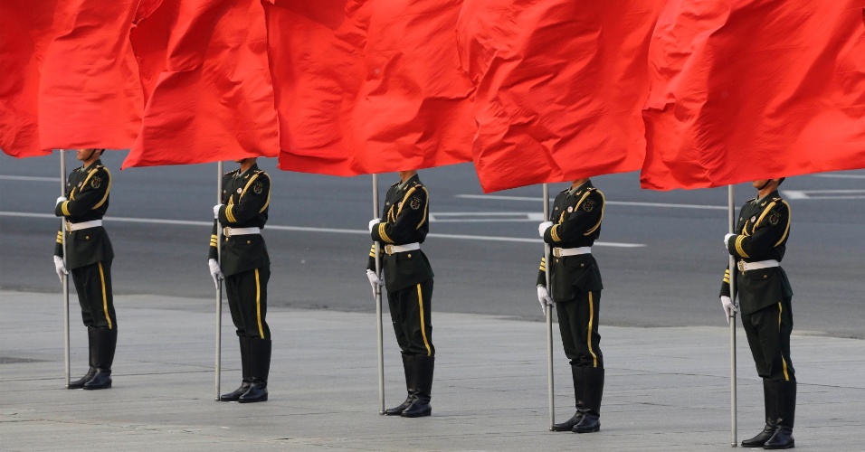 24.abr.2014 - Membros da guarda de honra seguram bandeiras durante cerimônia de boas-vindas para a rainha da Dinamarca, Margrethe II, fora do Grande Salão do Povo, em Pequim, na China