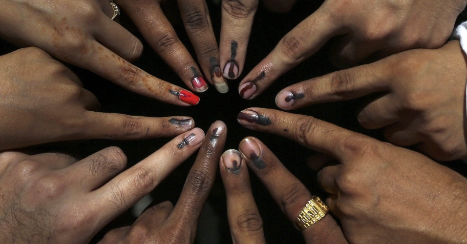 24.abr.2014 - Jovens que votaram pela primeira vez mostram os dedos manchados de tinta durante as eleições em Mumbai, na Índia