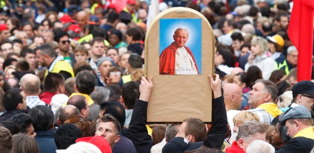 Fiel carrega imagem de João Paulo 2º durante cerimônia de canonização na praça de São Pedro, no Vaticano - 27.abr.2014 - Remo Casilli/Reuters