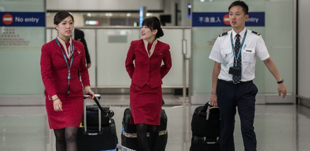 Comissárias de bordo da Cathay Pacific caminham pelo aeroporto internacional de Hong Kong: queixas de "uniformes sensuais" - Philippe Lopez/AFP