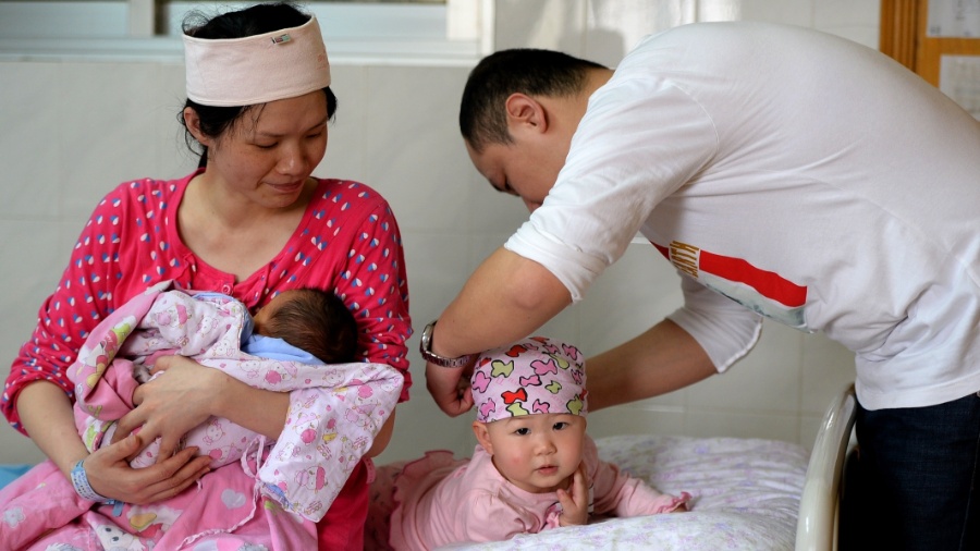 Casal de chineses cuida de seu bebê recém-nascido e da filha mais velha - Xinhua