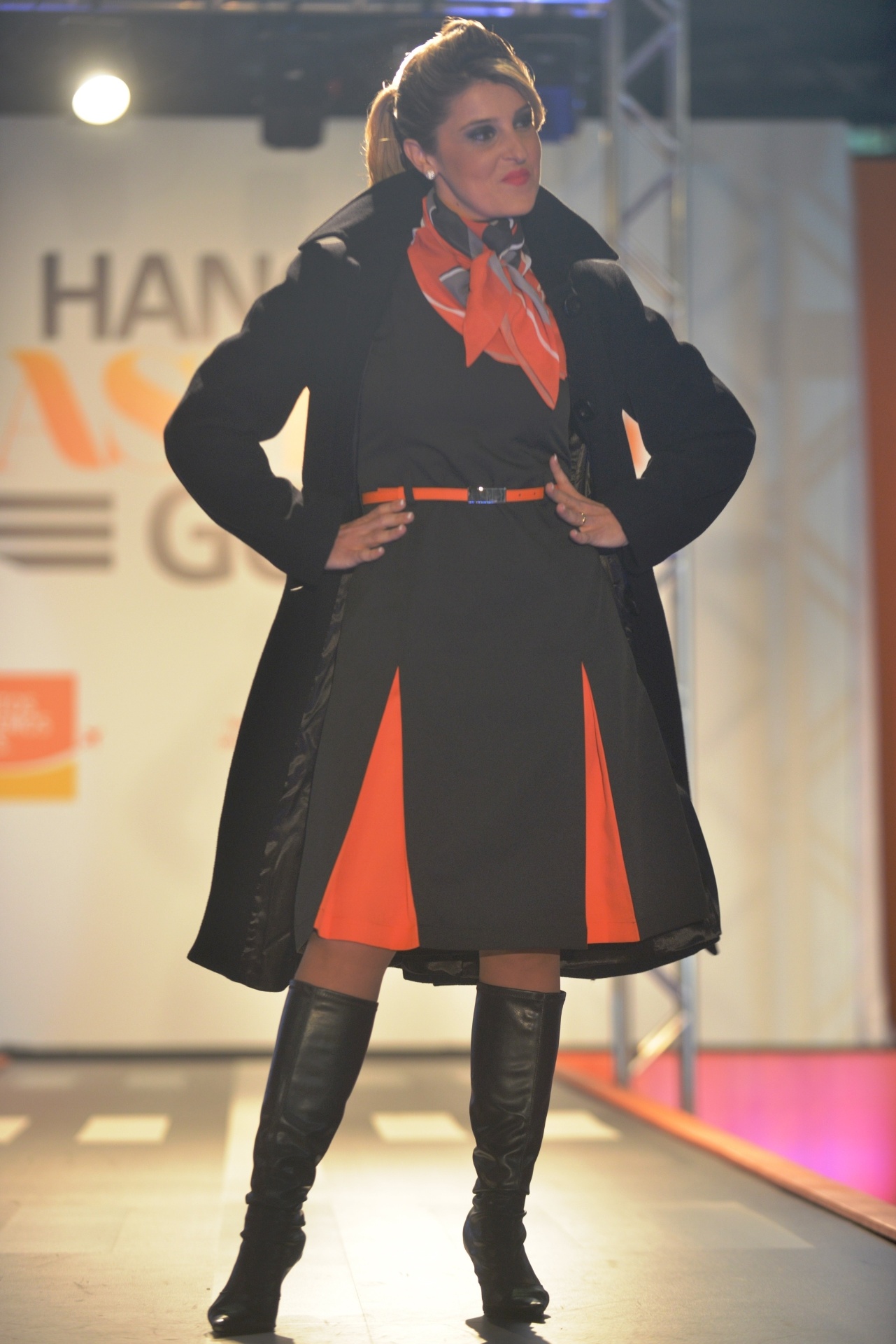 Comissária usa vestido nas cores chumbo e laranja, sobretudo preto e botas de cano longo. As peças fazem parte da nova coleção de inverno de uniformes da Gol Linhas Aéreas - Divulgação