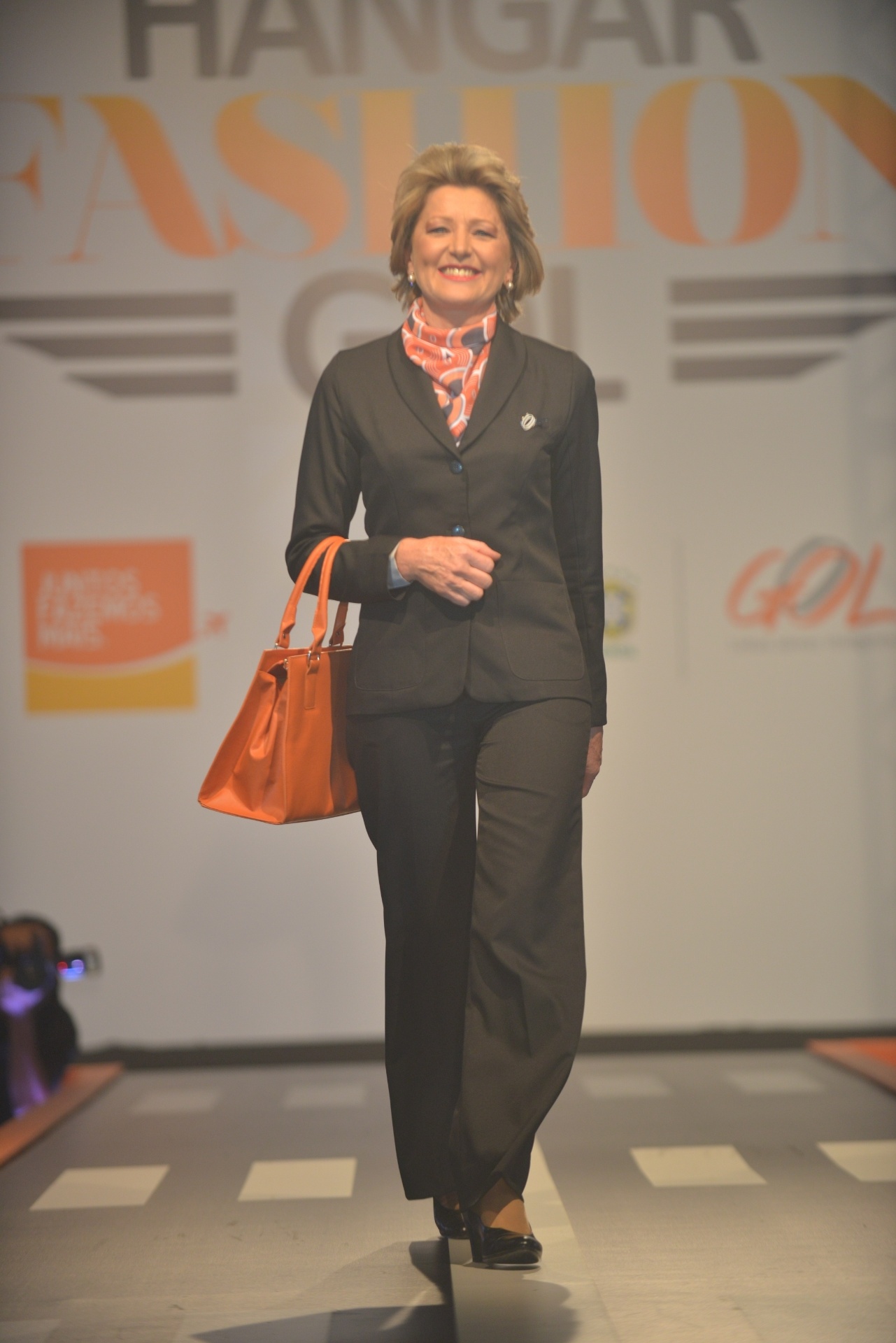 Uniforme da Gol Linhas Aéreas é composto de blazer e calça na cor chumbo e lenço de cor laranja. A companhia lançou nova coleção de peças para comissários e funcionários de aeroportos - Divulgação