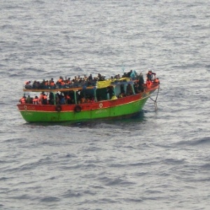 Imagem divulgada pela Marinha italiana mostra imigrantes resgatados em um barco na costa da Sicília - AFP