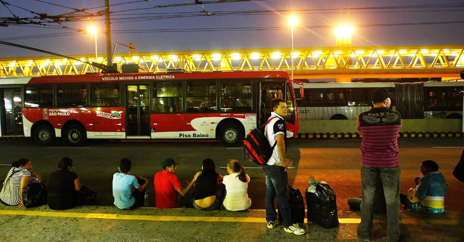 20.mai.2014 - Passageiros esperam sentados dentro do terminal Parque Dom Pedro 2º, no centro de São Paulo, na noite desta terça-feira (20), durante paralisação dos motoristas e cobradores de ônibus. Os seguranças do local bloquearam as catracas na tentativa de evitar a entrada de pessoas dentro do terminal