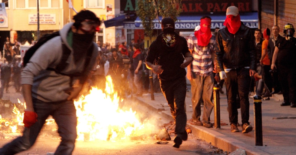 23.mai.2014 - Manifestantes mascarados entram em confronto com a polícia após funeral de Ugur Kurt, morto por bala perdida disparada por policiais em Istambul, nesta sexta-feira (23). Dois manifestantes foram mortos e oito policiais ficaram feridos nos confrontos que já duram dois dias no reduto esquerdista de Okmeydani, distrito de Istambul