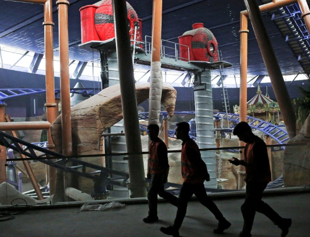 Trabalhadores caminham dentro de um parque de diversões em obras em Istambul, na Turquia, que faz parte de um grande empreendimento imobiliário em desenvolvimento na cidade - Tara Todras-Whitehill/The New York Times