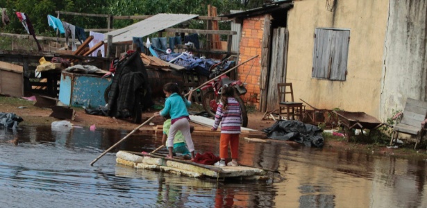 Crianças remam em inundação na cidade de Trinidad, perto de Assunção, no Paraguai - Jorge Adorno/Reuters