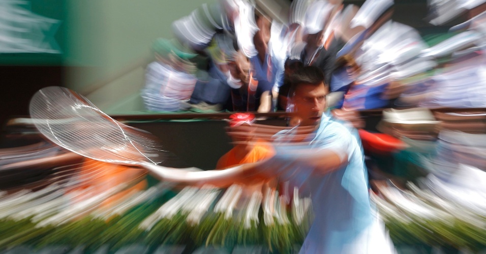 06.jun.2014 - Fotografia com efeito especial de zoom do tenista Novak Djokovic da Sérvia devolve a bola para Ernests Gulbis da Letónia durante partida no torneio de tênis do Aberto da França no estádio Roland Garros em Paris