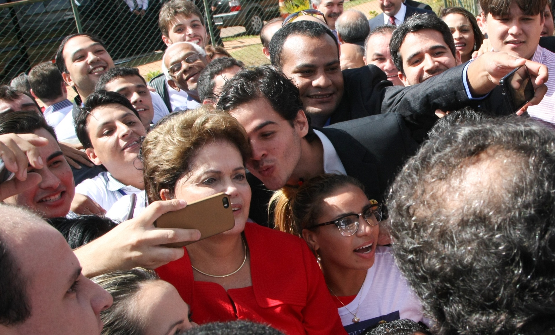 10.jun.2014 - Membro da juventude do PDT tenta dar beijo na presidente Dilma Rousseff em selfie na saída da convenção nacional do partido, nesta terça-feira (10). O PDT oficializou apoio à reeleição da presidente. Na votação, nenhum convencional levantou o crachá quando questionado quem era contra a aliança com a presidente - Joel Rodrigues/Folhapress