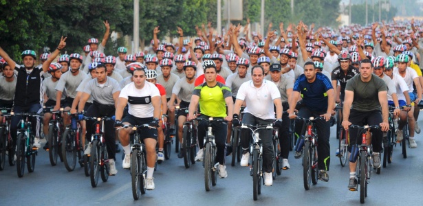O presidente do Egito, Abdel Fattah al Sisi (dir., de branco) é acompanhado em passeio de bicicleta com centenas de egípcios no Cairo; Sisi pediu que a população ande mais à pé e de bicicleta para economizar combustível  - Presidência do Egito/Reuters
