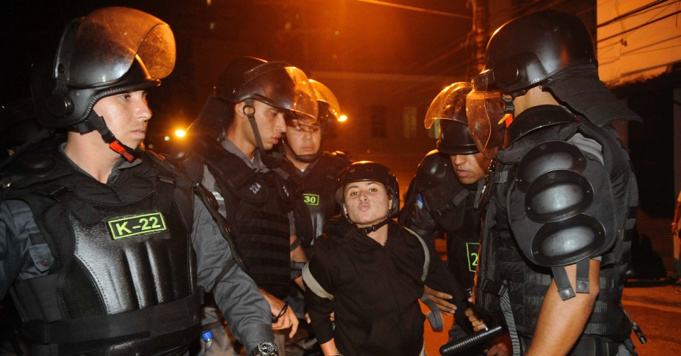 28.jun.2014 - Manifestante solta beijo para câmera enquanto é detida por policiais durante protesto contra a Copa do Mundo, nas proximidades da praça da Saenz Peña, na zona norte do Rio de Janeiro