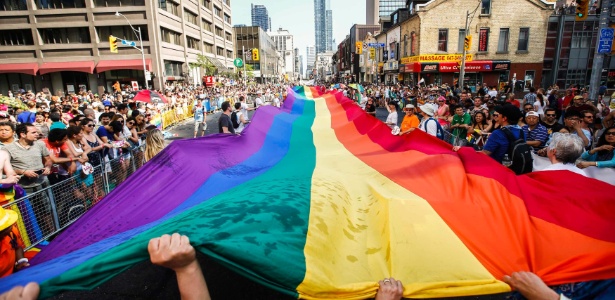 Ativistas seguram bandeira gigante do orgulho gay durante parada em Toronto, no Canadá, neste domingo (29). Toronto realiza a WorldPride, uma semana inteira de eventos voltados para a comunidade LGBT - Mark Blinch/Reuters