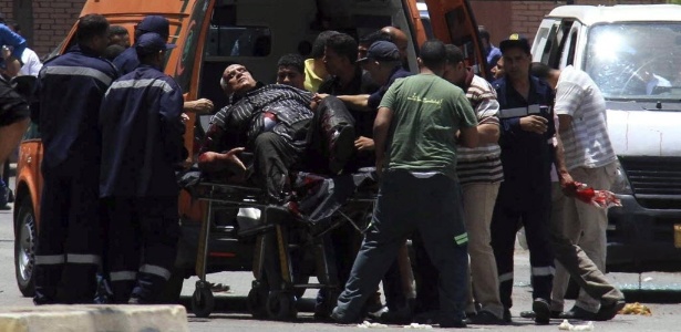 Homem ferido é colocado em ambulância após a explosão de uma bomba em frente ao palácio presidencial