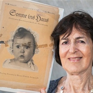 A professora Hessy Taft, 80, segura o exemplar da revista nazista "Sonne ins Haus", com sua foto na capa - Reprodução/The Telegraph