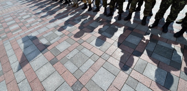 Sombras de soldados são vistas no chão, em frente ao parlamento em Kiev - Sergei Supinsky/AFP