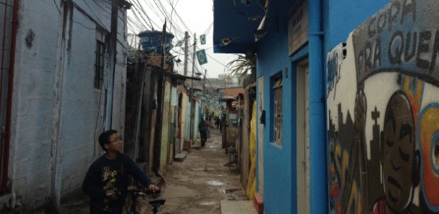 Em uma das vielas da favela, o menino observa "Copa pra quem?" - BBC Brasil