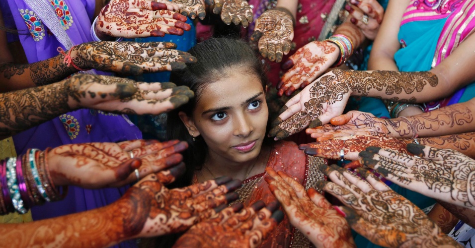 11.jul.2014 - Alunas mostram mãos decoradas com henna durante competição que marca o Dia Mundial da População, na cidade de Ahmedabad, na Índia