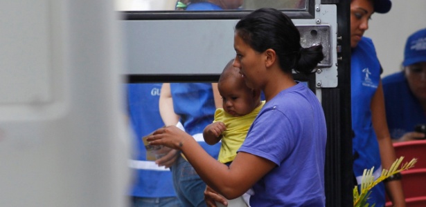 Mulher e seu filho entram em ônibus no aeroporto San Pedro Sula, em Honduras, após serem deportados - Jorge Cabrera/Reuters