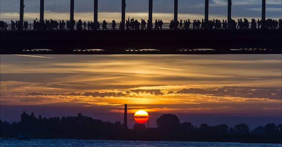 15.jul.2014 - Pessoas atravessam o rio Waalbrug durante o amanhecer no primeiro dia do evento anual "a Vierdaagse", em Nijmegen, na Holanda