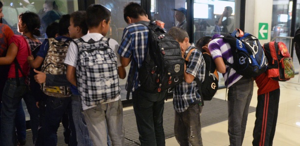 Grupo de 16 menores guatemaltecos retidos no México enquanto tentavam entrar ilegalmente nos EUA faz fila no aeroporto da Cidade de Guatemala após deportação - Johan Ordonez/AFP