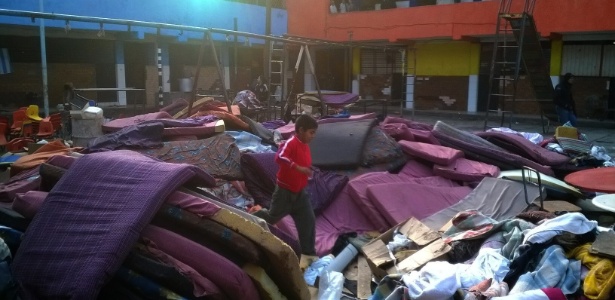 Menino corre entre colchões acumulados em pátio do abrigo La Gran Família, em Zamora (México) - Efe