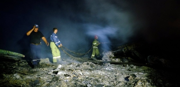 17.jul.2014 - Bombeiros trabalham no local em que o voo MH17 da Malaysia Airlines caiu com 298 pessoas - Dominique Faget/AFP