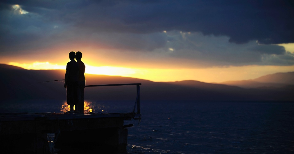 17.jul.2014 - Meninos lançam suas linhas de pesca na margem do Lago Ohrid na aldeia de Trpejica durante uma noite tempestuosa, na Macedônia