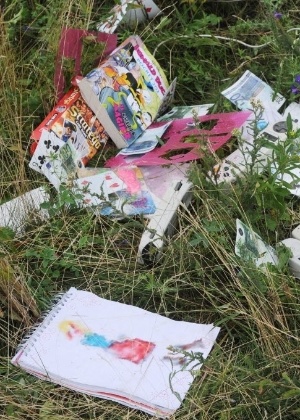 Livros infantis, desenhos e dinheiro estão entre os objetos encontrados no local onde caiu um avião da Malaysia Airlines - Dominique Faget/AFP