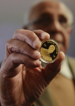 Ex-preso político Ahmed Kathrada segura moeda de ouro em homenagem a Mandela - Divulgação/Reuters