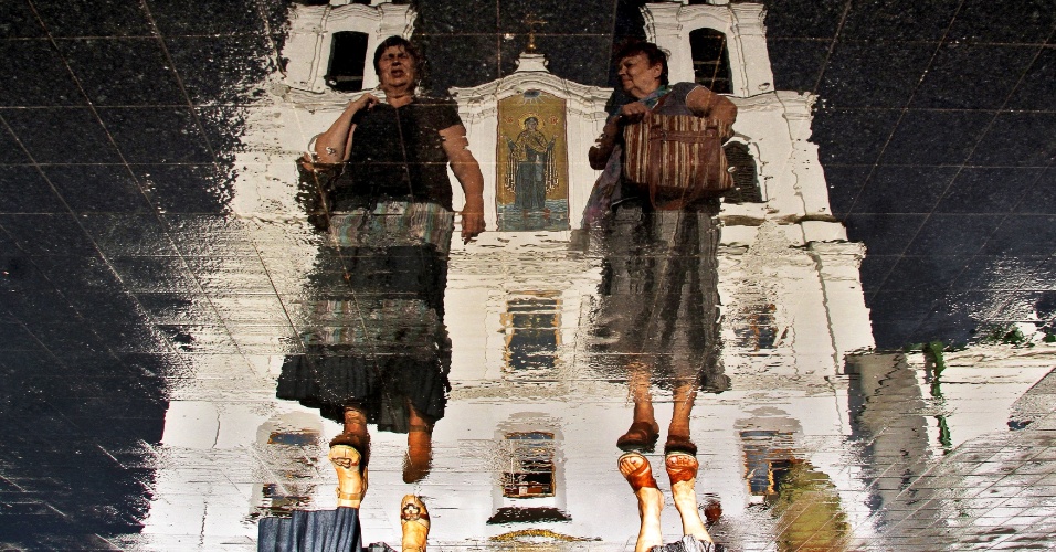 21.jul.2014 - Duas mulheres caminham próximo à catedral ortodoxa Svyato-Dukhov (Espírito Santo) em Minsk, na Bielorrússia
