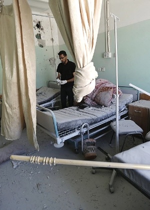 Funcionário palestino inspeciona os danos no hospital Al-Aqsa na faixa de Gaza; ataque israelense matou ao menos 4 - Mohammed Abed/AFP 