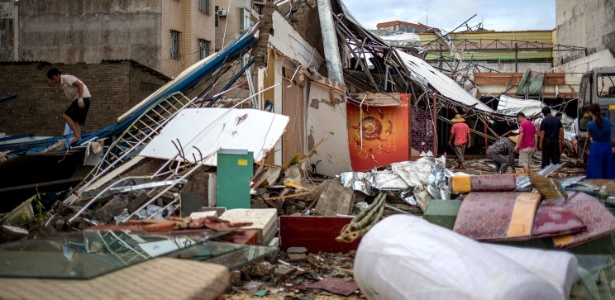 Moradores limpam destroços em Zhanjiang, no extremo sul da China, após a passagem do tufão Rammasun - Reuters