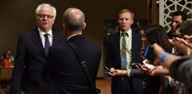 Vitaly Churkin (à esquerda), embaixador da Rússia na ONU conversa com jornalistas do lado de fora da sala do Conselho de Segurança da ONU, em Nova York minutos antes da reunião de emergência convocada para discutir a situação na faixa de Gaza - Stan Honda/AFP