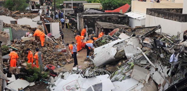 24.jul.2014 - Equipes de resgate e bombeiros investigam os destroços do voo GE222 - Sam Yeh/AFP